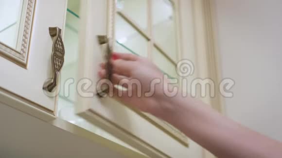 女性手打开厨房柜门在里面用架子摆放玻璃视频的预览图