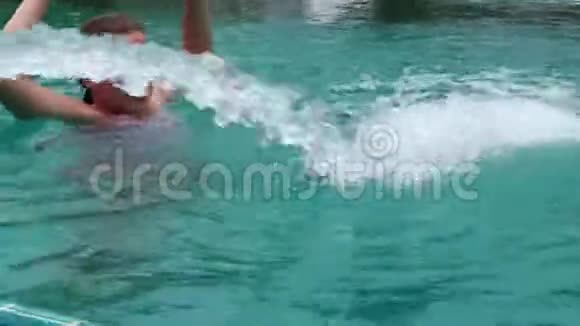 穿着泳装的少女在游泳池里用喷水游泳视频的预览图