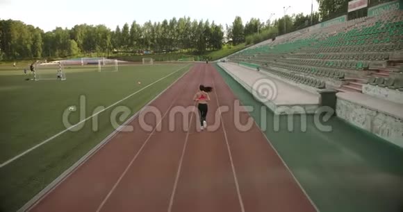空中飞行苗条的运动女孩在体育场慢跑有魅力的年轻人在户外锻炼视频的预览图