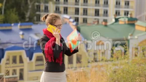 一位戴着眼镜的美女在城市背景下通过电话打来视频的预览图