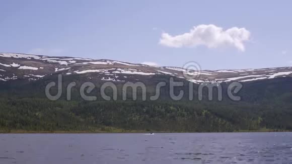 在水面上反射风暴云的山湖景色岸上的针叶林视频的预览图
