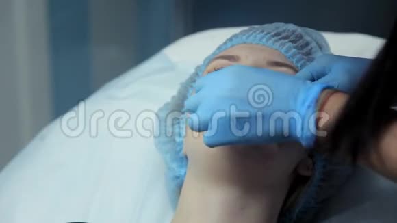 医生美容师在手术前润滑女孩嘴唇溶液以增加嘴唇肉毒杆菌视频的预览图
