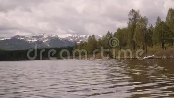 在水面上反射风暴云的山湖景色岸上的针叶林视频的预览图
