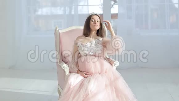 穿着粉色别致礼服的怀孕少女视频的预览图