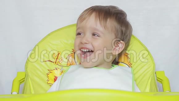 坐在桌子上的孩子笑着孩子的眉毛移动视频的预览图
