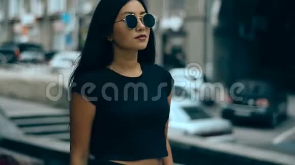 年轻的亚裔深色头发的少女在大街上走来走去视频的预览图