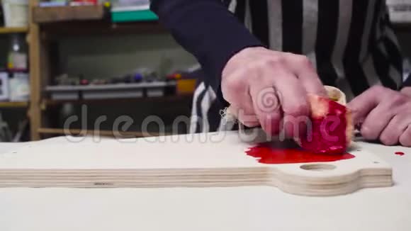 男人用上釉把家具部分涂上颜色视频的预览图