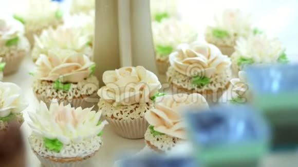 特写各种美味的甜点纸杯蛋糕奶油蛋糕鲜奶油用奶油做的花节日装饰视频的预览图