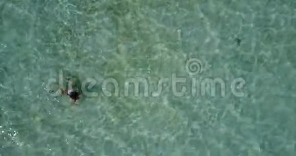 空中飞行无人机马尔代夫白色沙滩1人年轻美丽的女士在阳光明媚的阳光下游泳视频的预览图