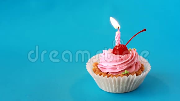 生日蛋糕与樱桃和燃烧蜡烛为生日在蓝色背景延时录像视频的预览图