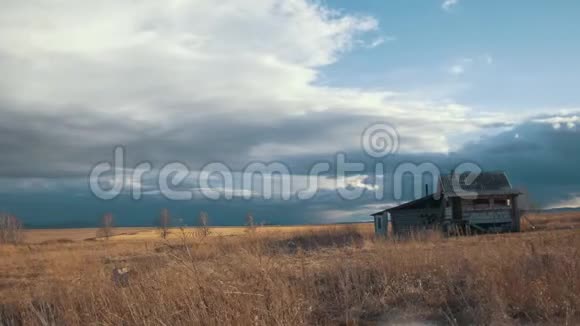 春天的田野里一幢幢小的独栋的房子顶着多云的天空时间流逝视频的预览图