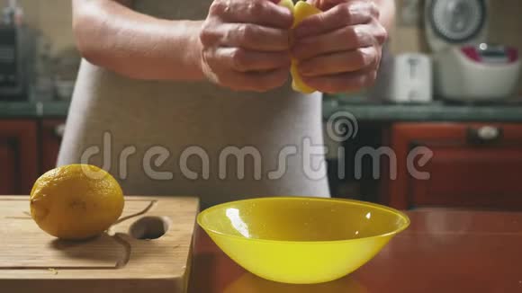厨房里的一个女人挤出柠檬汁4k慢镜头特写多利镜头视频的预览图