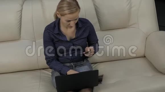 女士在笔记本电脑上支付电子订单信用卡使用网上购物慢动作视频的预览图