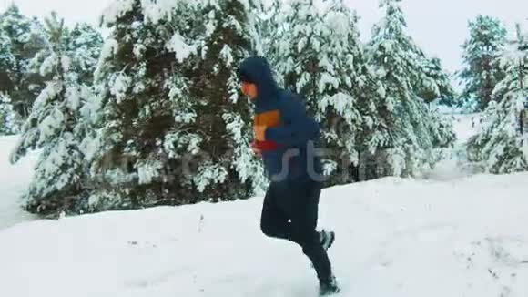 运动员穿过白雪森林冬季训练期间运动员在寒冷的雪天外跑步视频的预览图