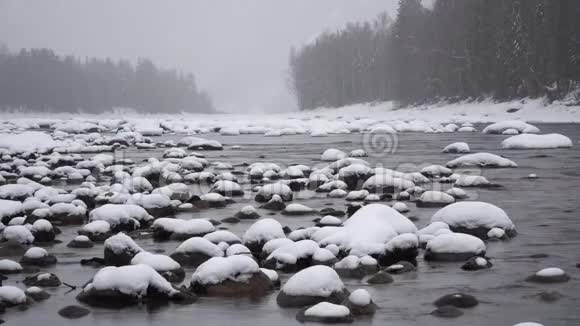 大雪期间在山河上的冬季景象视频的预览图