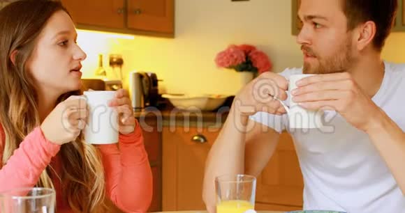 一对夫妇在厨房的餐桌上喝咖啡视频的预览图