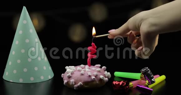 派对粉红色的甜甜圈和红色的节日蜡烛在上面金色纸屑掉落视频的预览图