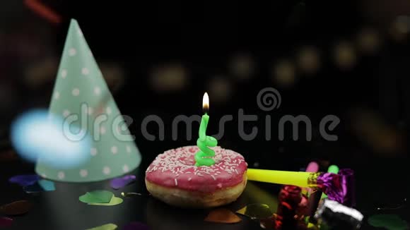 派对粉红色的甜甜圈和红色的节日蜡烛在上面金色纸屑掉落视频的预览图
