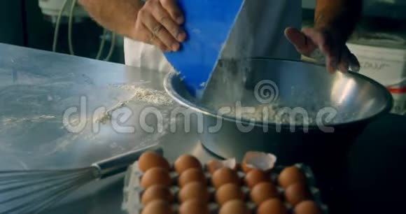 男厨师在厨房搅拌鸡蛋和面粉视频的预览图