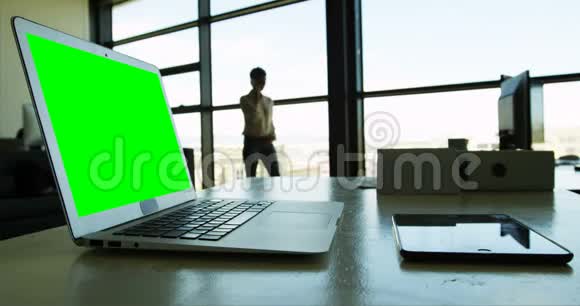 当女商人在4k手机上聊天时桌上放着笔记本电脑和数码平板电脑视频的预览图
