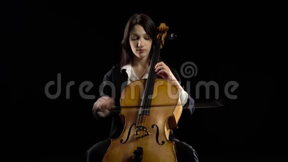 在黑暗的房间里音乐家坐着演奏中提琴排练一篇作文黑色背景视频的预览图