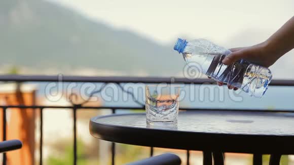 将淡水饮料倒入客厅桌子上的玻璃中有山有海的背景阳光明媚视频的预览图