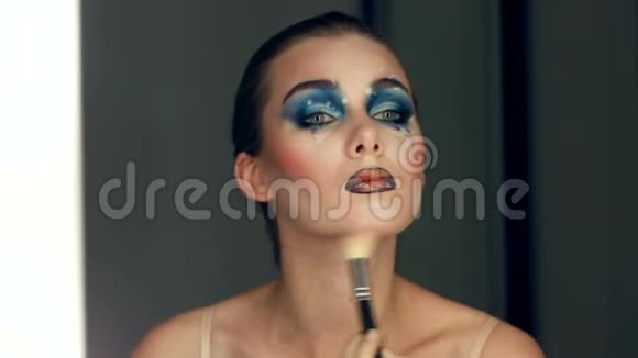一个年轻漂亮的女孩在镜子里化妆时的倒影视频的预览图