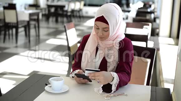 使用信用卡的妇女在手机银行应用程序上核实账户余额网上购物视频的预览图