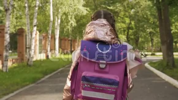 带背包的小女孩带着花束去上学回到学校视频的预览图