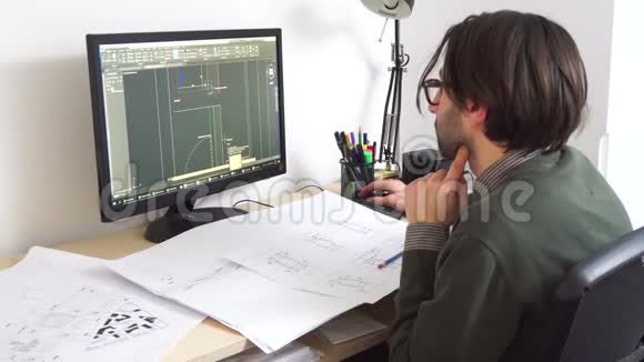 年轻建筑师男性在办公桌上办公笔记本电脑上书桌上有蓝图视频的预览图