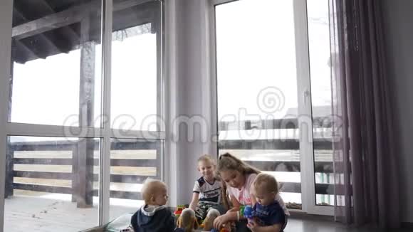 快乐的孩子们一起玩儿童概念在私人住宅中的儿童坐在地板上的全景窗和视频的预览图