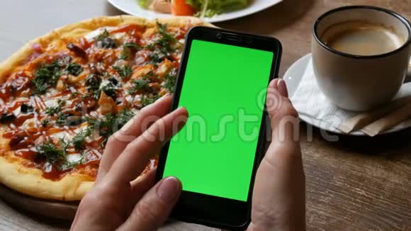 黑色智能手机上的Chroma键或绿色屏幕女性手中有一个精心修剪的指甲背景是一个大的视频的预览图