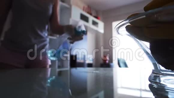 家庭主妇喷洒清洁剂擦拭玻璃桌视频的预览图
