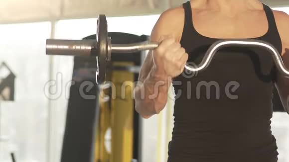 适合男性运动员用强壮的肌肉手臂提升卷曲杆健美锻炼视频的预览图
