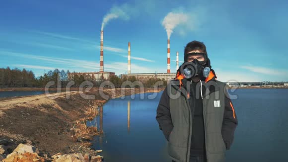 戴呼吸器或防毒面具的青年画像背景烟来自水力发电的管道视频的预览图
