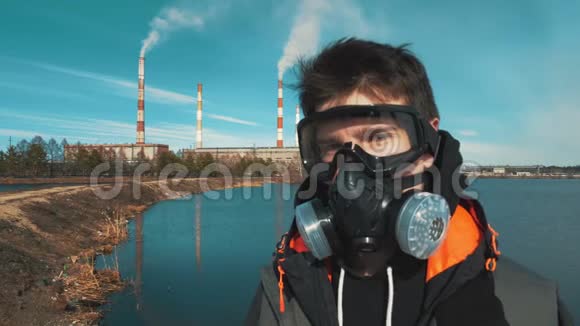 戴呼吸器或防毒面具的青年画像背景烟来自水力发电的管道视频的预览图