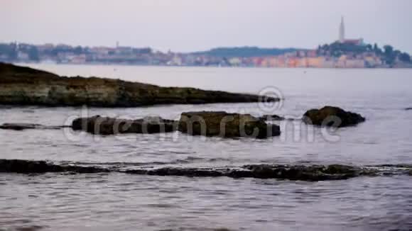 在阴沉的早晨前景是波浪的罗维尼奥海景视频的预览图