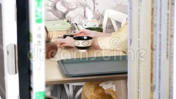 日本餐馆的女人手里拿着一杯茶视频的预览图