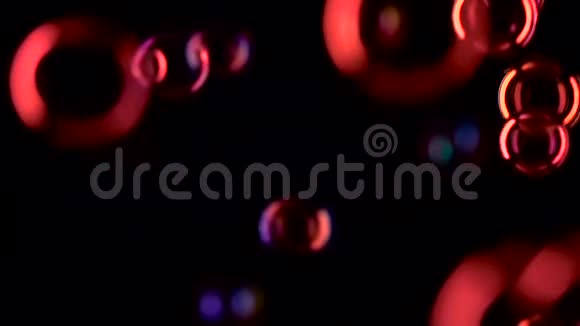 红色的肥皂泡在空气中飞得很近慢动作黑色背景视频的预览图