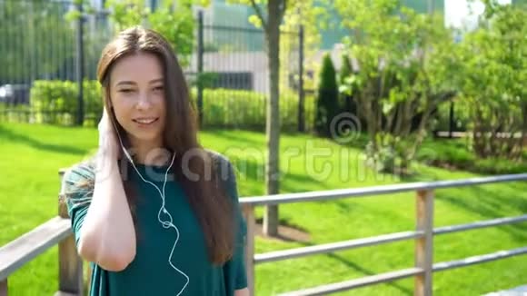 年轻女子用耳机听音乐迷人的女性带着可爱的微笑在咖啡馆休息视频的预览图