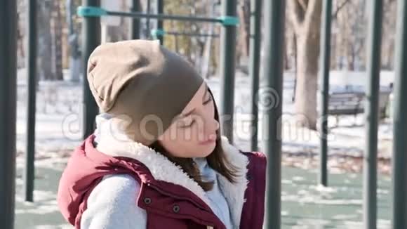 冬天阳光明媚的一天一个运动女孩在运动场上做热身运动的肖像视频的预览图