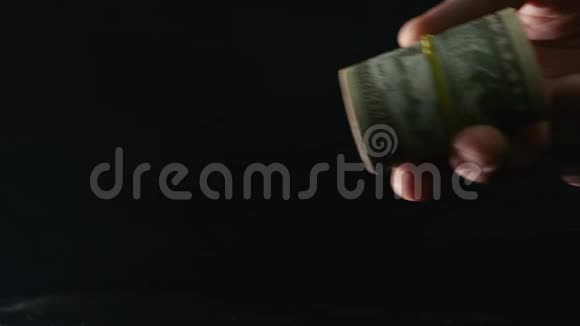 转账零件男人手里拿着一捆钱贴在黑色的背景上视频的预览图