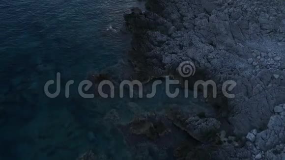 日落于平静的大海从岩石中飞翔视频的预览图