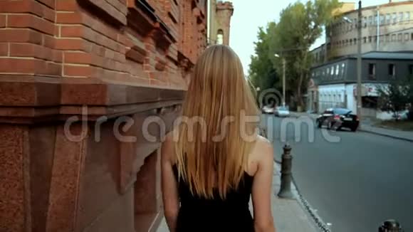 瘦小的金发女郎在城里散步视频的预览图