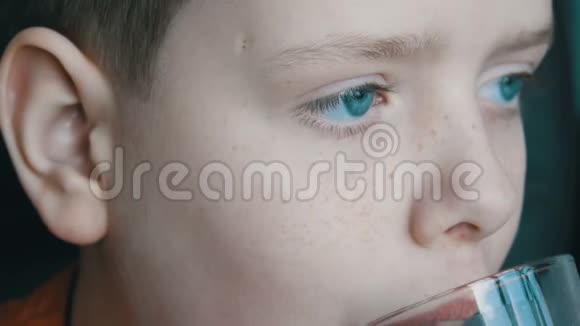 小男孩蓝眼睛雀斑从玻璃烧杯里喝牛奶擦他的奶胡子视频的预览图