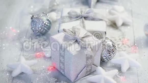 圣诞桌装饰两份银色礼物雪片和白色星星的灯光视频的预览图