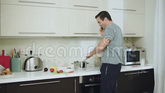 微笑的男人在现代厨房做健康的晚餐视频的预览图