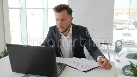 厌倦了工作过度的商人愤怒的商人用笔记本电脑挨着桌子年轻的经理头痛视频的预览图