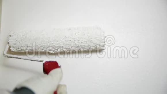 油漆滚筒在白色背景上涂上白色改善家居环境视频的预览图