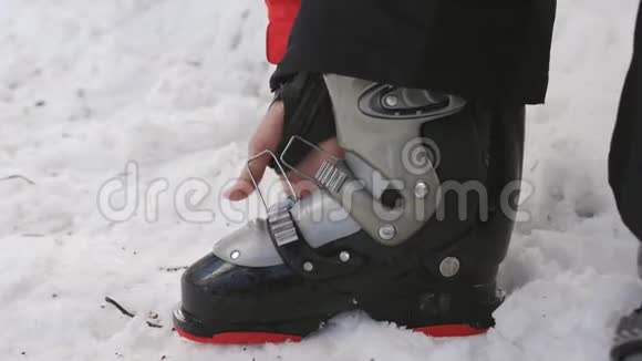 女人穿着滑雪靴在你的脚上纽扣特殊的紧固件视频的预览图